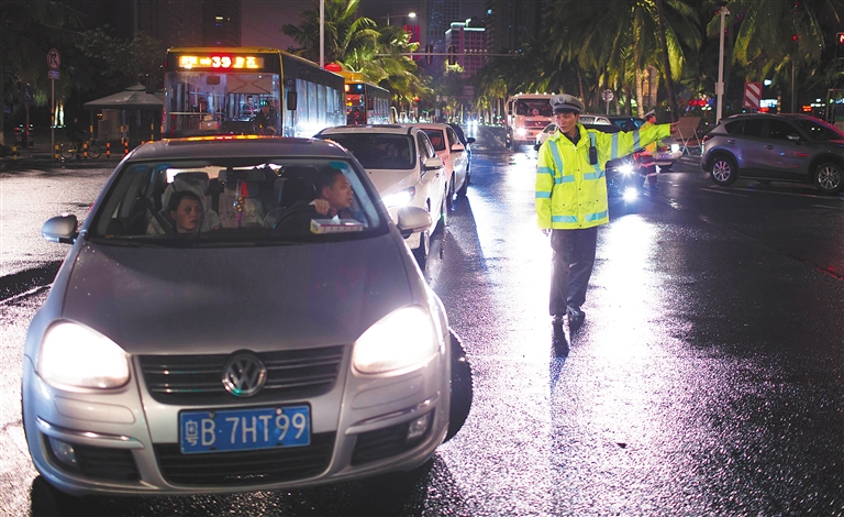 海口市滨海大道，交警为过海滞留车辆提供交通信息